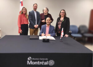Mohamed Barhone signant le livre d'or de l'arrondissement Ahuntsic-Cartierville