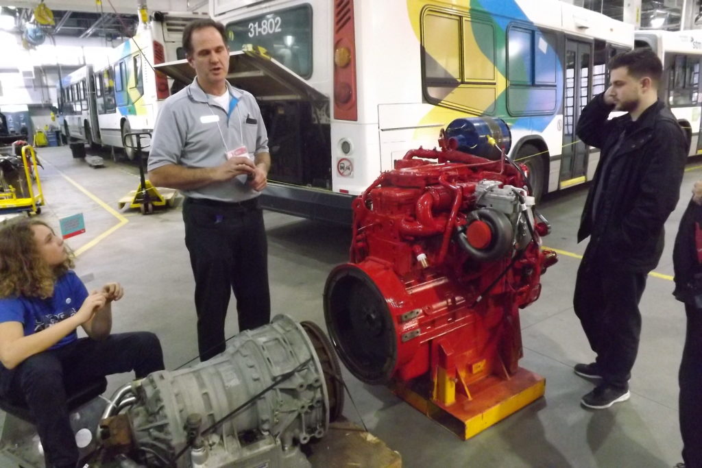 Employé expliquant aux citoyens comment remettre un moteur et une transmission à neuf (Photo : jdv - P. Rachiele)